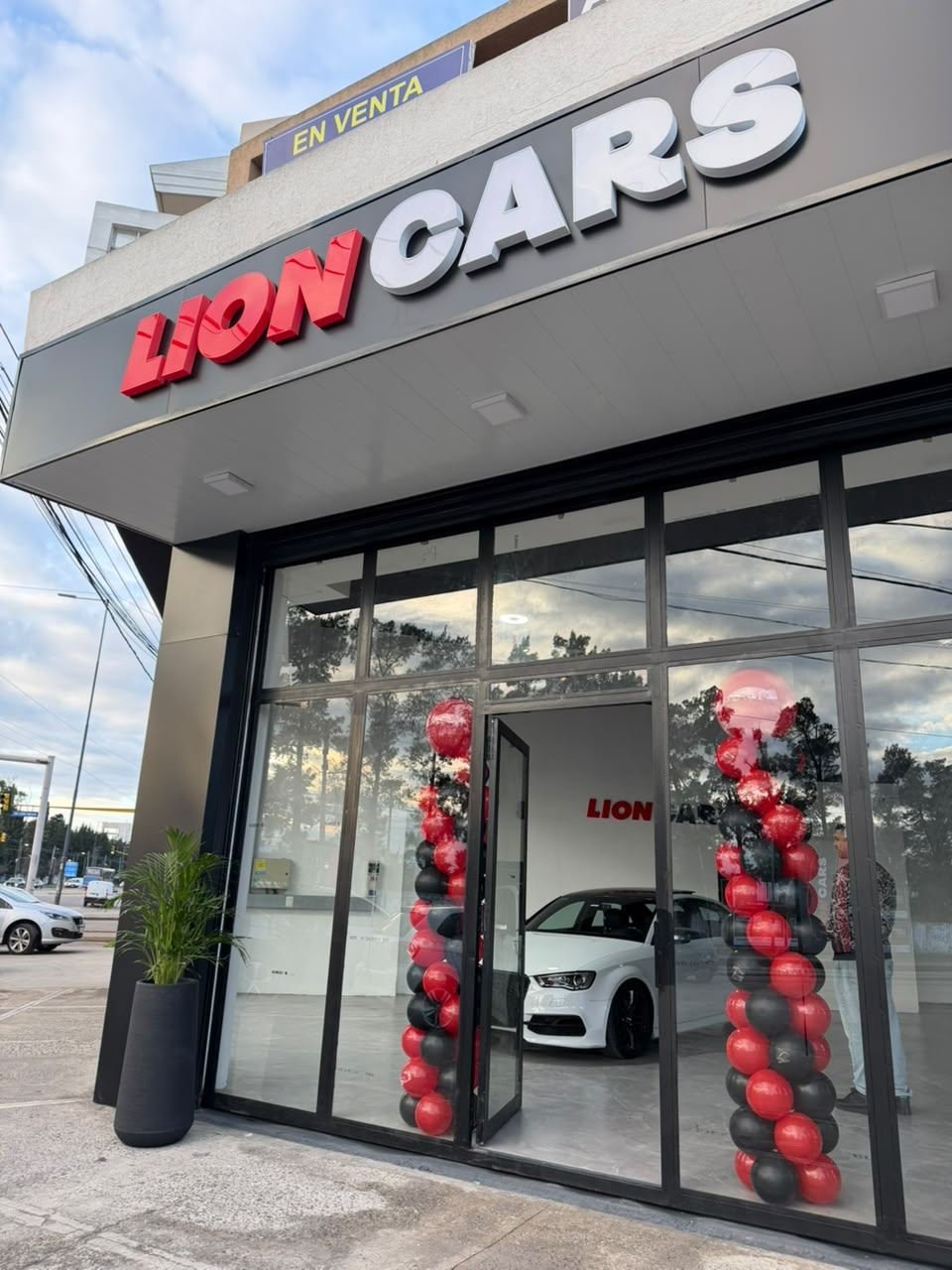 Fachada de la nueva agencia Lion Cars con globos rojos y negros