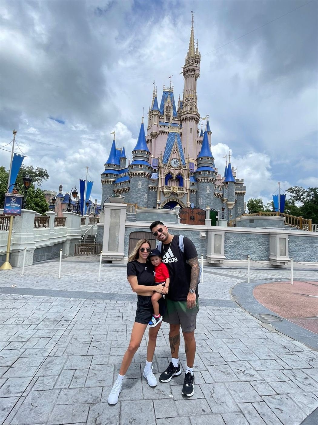 Nacho con su familia frente al castillo de un parque temático